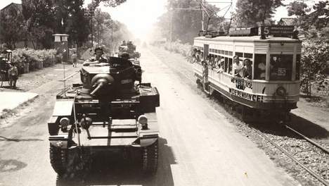Hierbij de bijschrift: Britse tanks patrouilleren in de straten van Batavia. Op de tram onafhankelijkheidsleuzen. (Opname: 29-10-1945) BeeldbankWO2/NIOD Het originele pers-bijschrift luidt: 'Tanks of C Squadron, P.A.V.O. (11th Frontier Force) parade through Batavia, 29th October, 1945. The tank 'Cushlan' with C.O. Squadron, Major B.P. Boyd, in Oude Tamarinde Laan'.